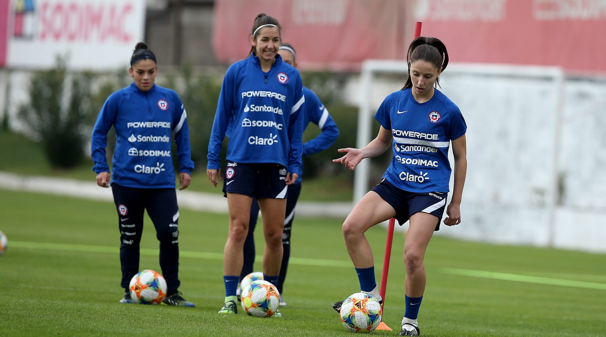 Tres futbolistas haciendo fila para entrenar