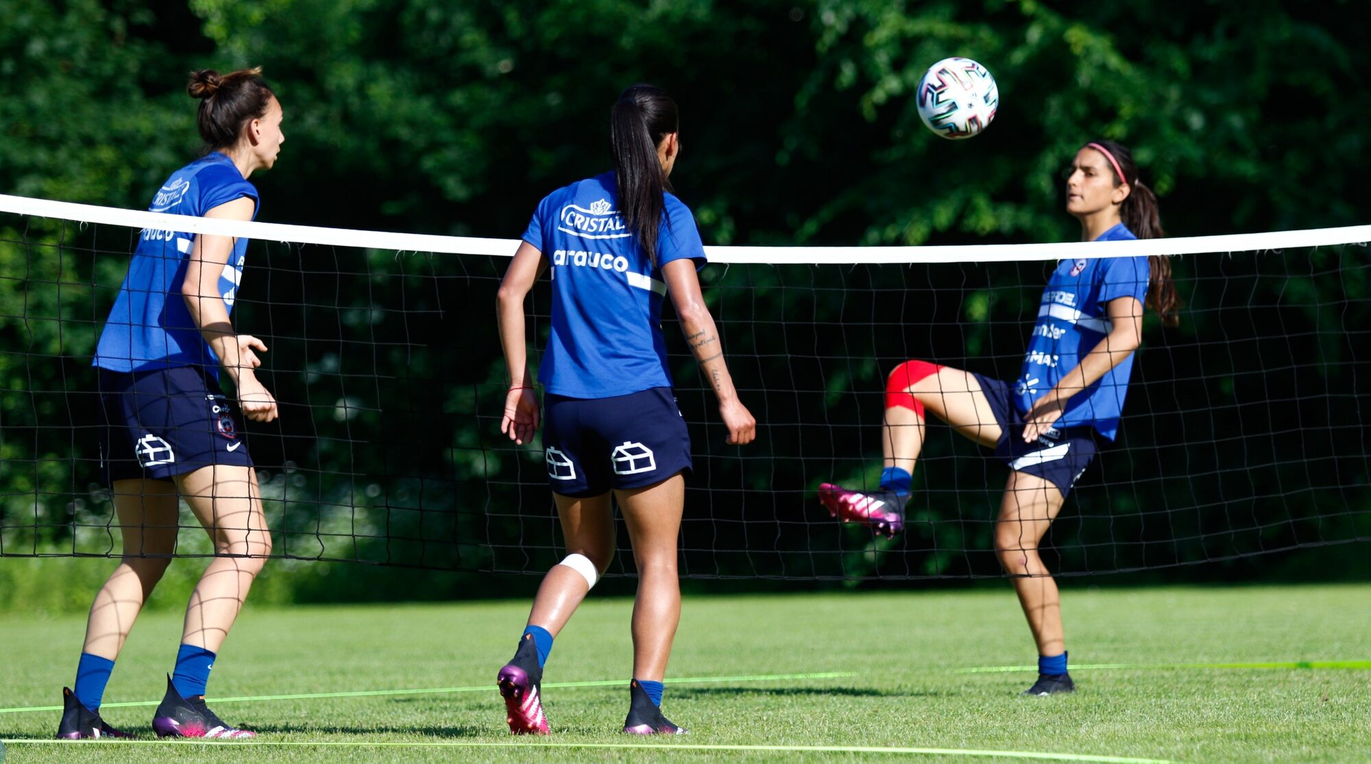 Tres futbolistas de la selección Chilena jugando fútbol tenis