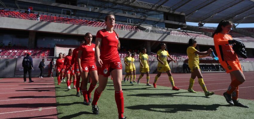 Jugadoras de ambos equipos entrando a la cancha en fila