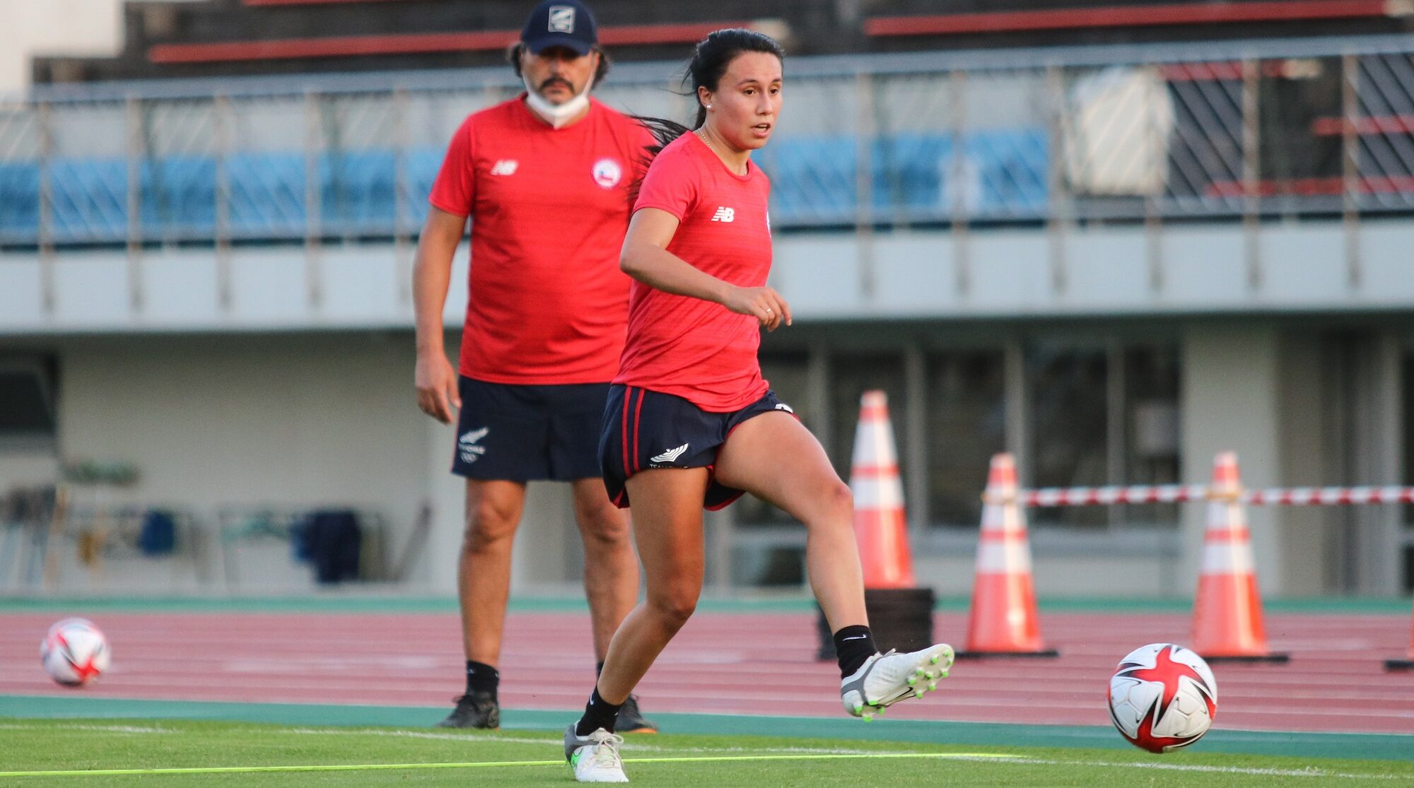 Camila Sáez adelante pasando la pelota. Atrás el DT José Letelier viendo el entrenamiento