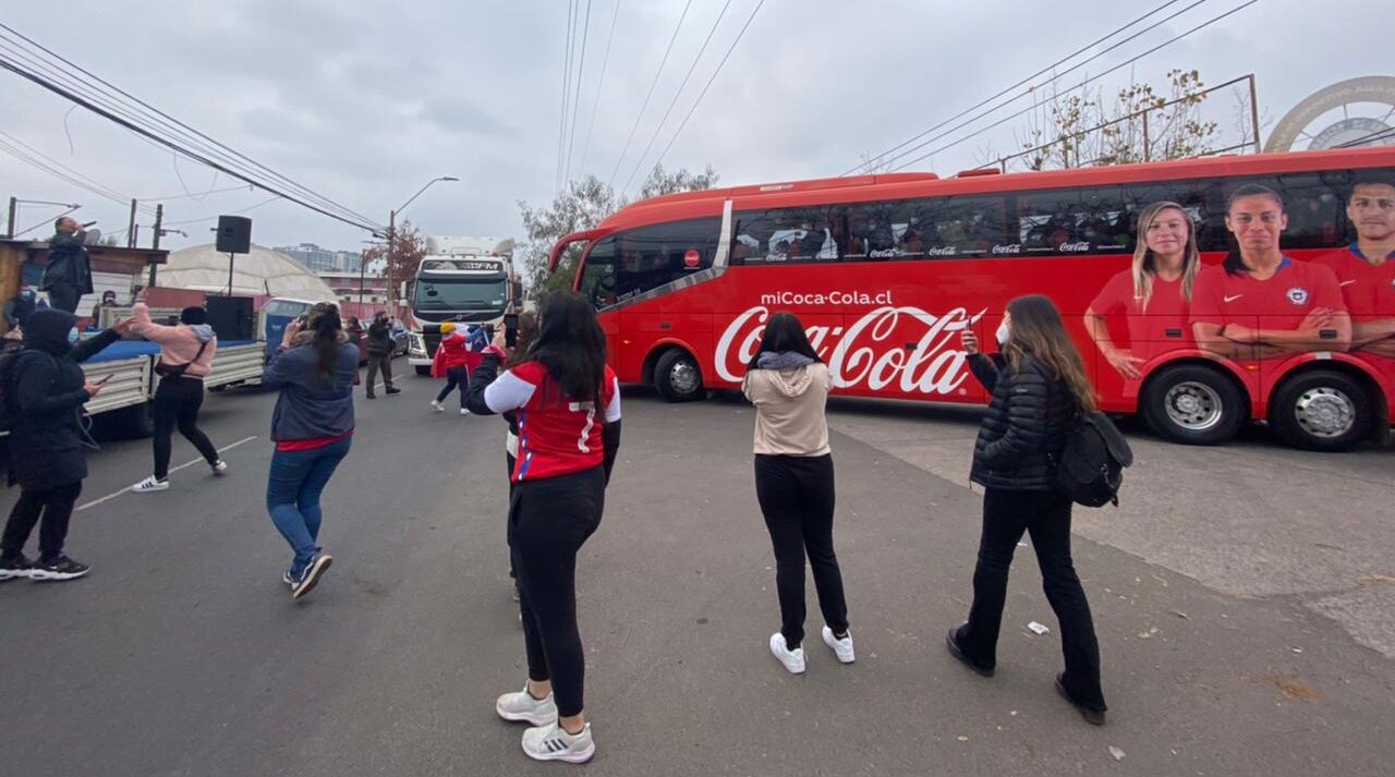 a la izquierda la cantante Catana, a la derecha el bus de la Selección Chile y también hinchas